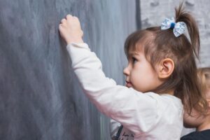 ילד יושב לבדו בפינת הגן ונמנע מקשר עין עם חבריו